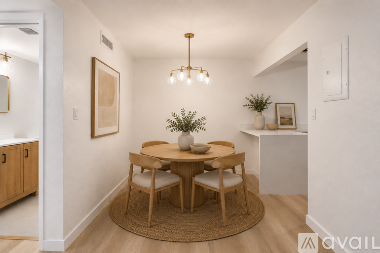 A dining room with a round table and chairs.
