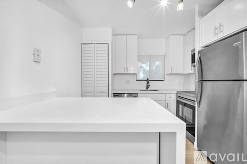 A kitchen with white cabinets and appliances.