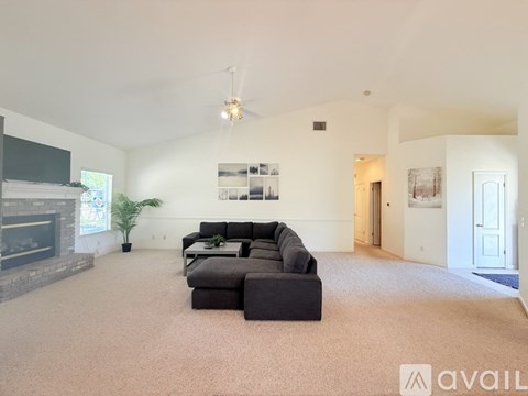 A spacious living room with a fireplace and a large couch.