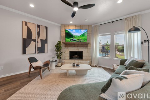A living room with a fireplace, a TV, and a painting on the wall.