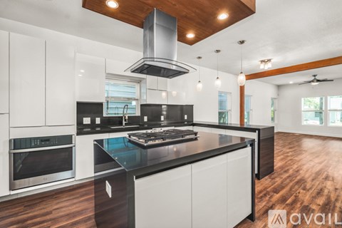 A modern kitchen with a black countertop and white cabinets.