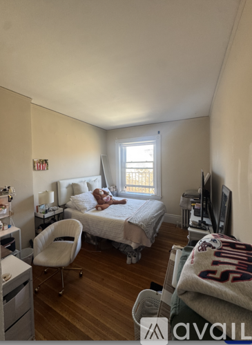 A bedroom with a bed, chair, and window.