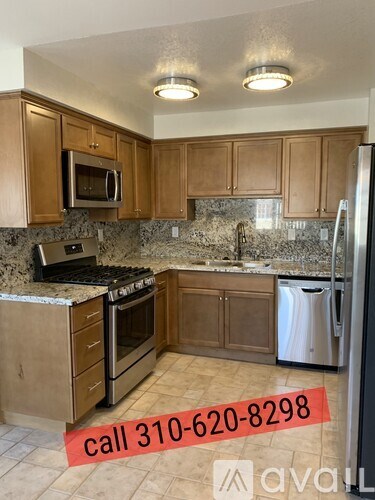 A kitchen with a refrigerator, microwave, and oven.