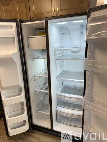A white refrigerator with its door open and shelves visible.