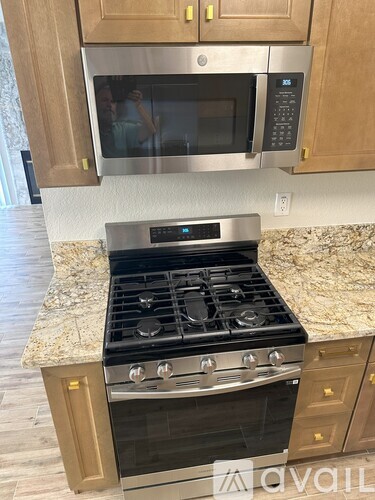 A kitchen with a stove and microwave above it.