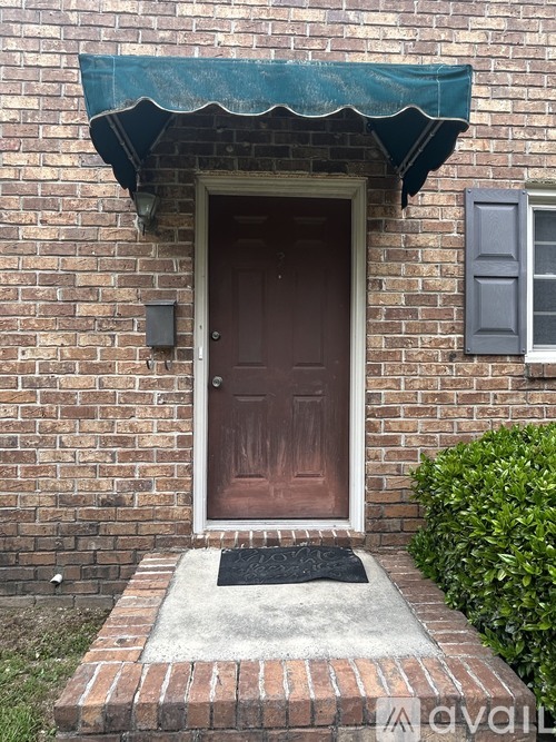 A brown door is on a brick house.