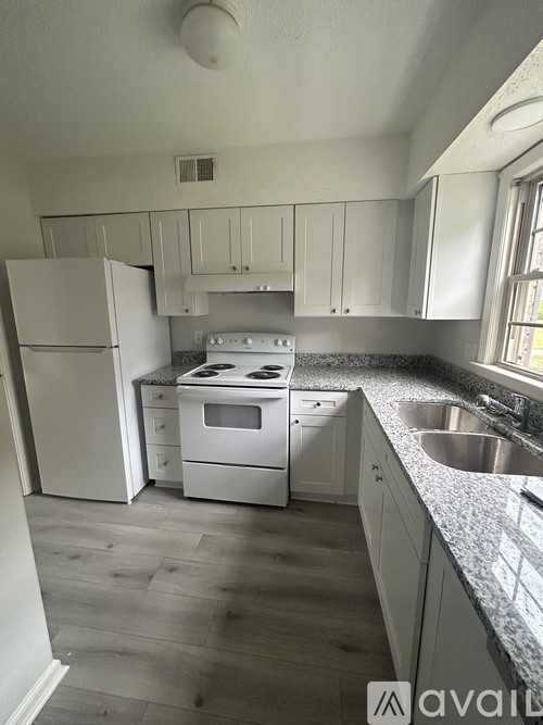 A kitchen with white appliances and cabinets.