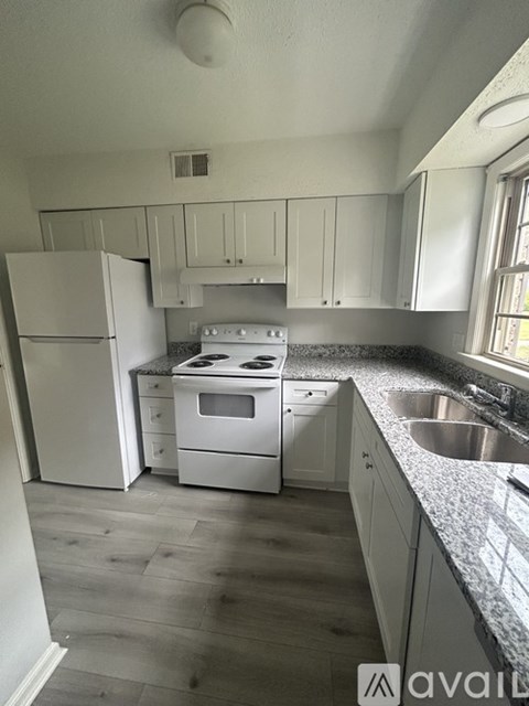A kitchen with white appliances and cabinets.