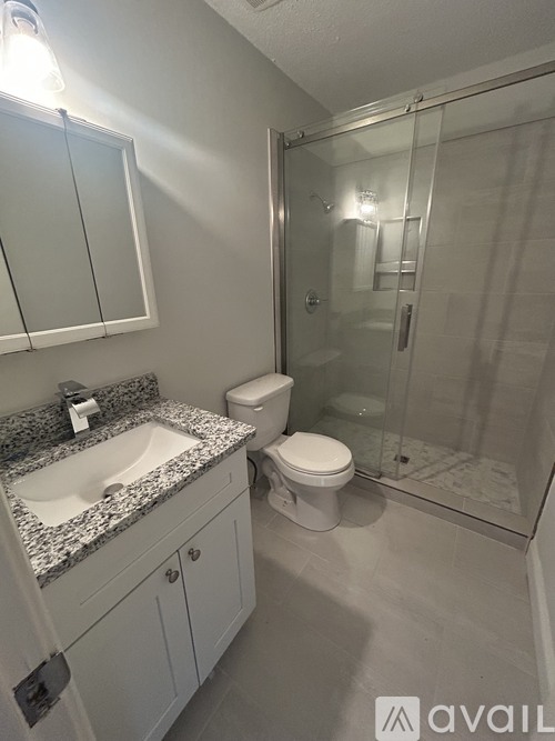 A bathroom with a sink, toilet, and shower.