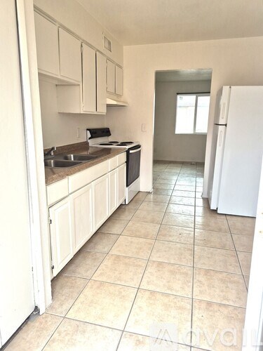 A kitchen with white appliances and cabinets.