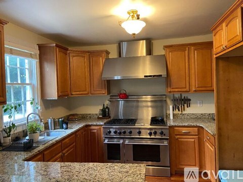 A kitchen with wooden cabinets and granite countertops.