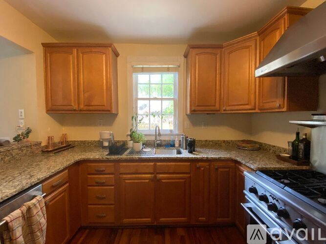 A kitchen with wooden cabinets and a granite countertop.