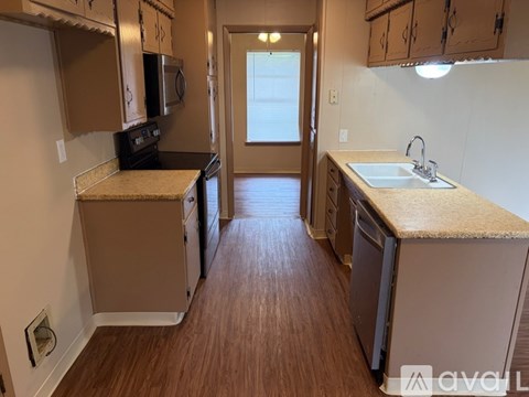 A kitchen with brown cabinets and a white sink.