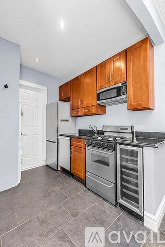 A kitchen with wooden cabinets and a white refrigerator.