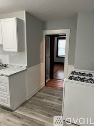 A kitchen with a white counter top and a white stove top oven.