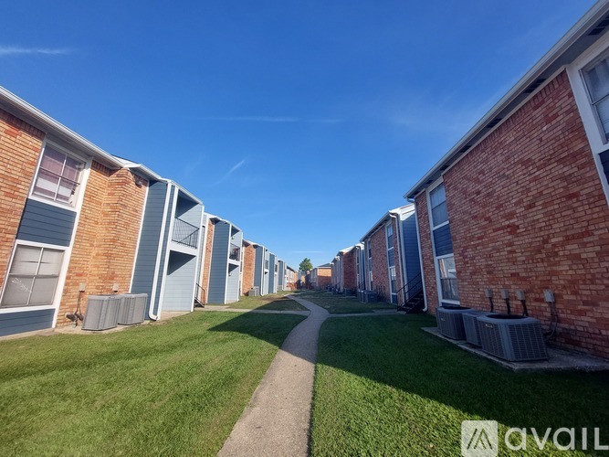 A row of red brick houses with a clear blue sky above.
