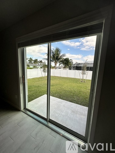 A view of a backyard through a sliding glass door.