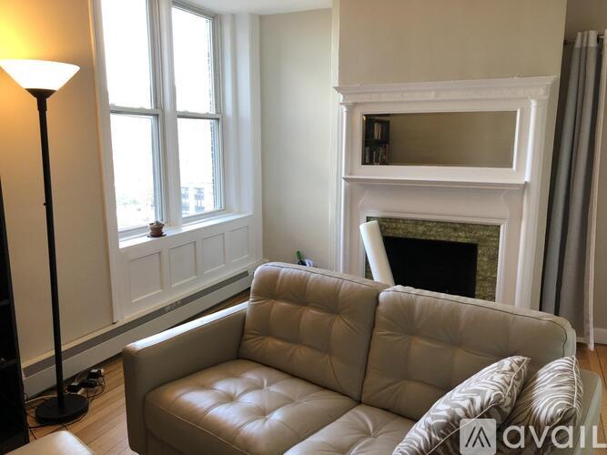 A living room with a beige couch and a fireplace.