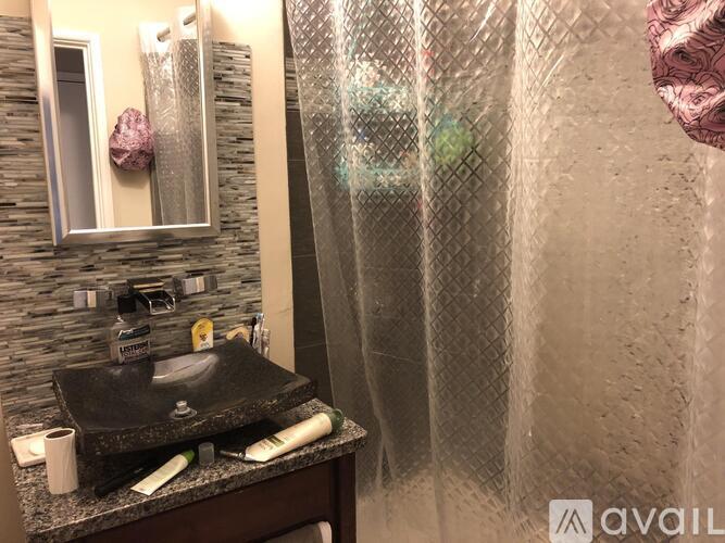 A bathroom with a black sink and a shower curtain.