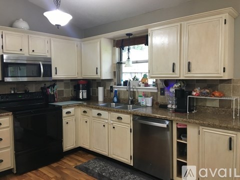 A kitchen with wooden cabinets and black appliances.