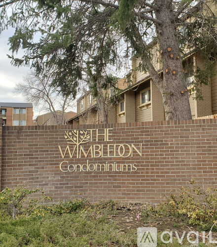 A brick wall with the words "The Wimbledon Condominiums" written on it.
