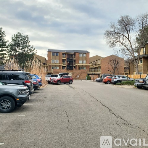 A parking lot with cars and a building in the background.