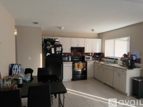 A kitchen with black appliances and white cabinets.
