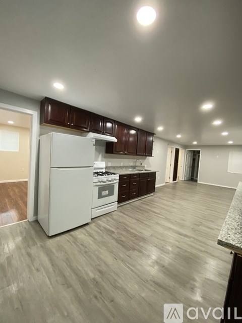 A kitchen with a white refrigerator and wooden cabinets.