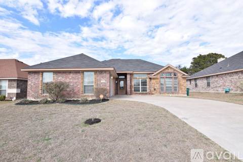 A brick house with a large front yard is for sale.