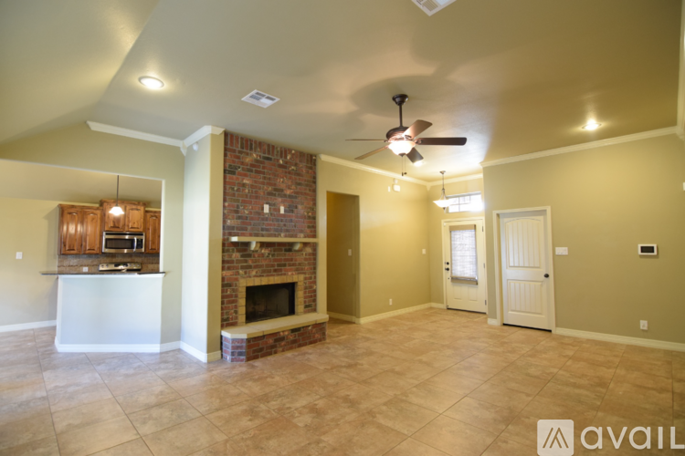 A living room with a fireplace and a fan on the ceiling.