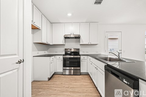 A kitchen with white cabinets and a black dishwasher.