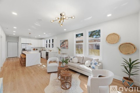A living room with a white couch and a wooden floor.