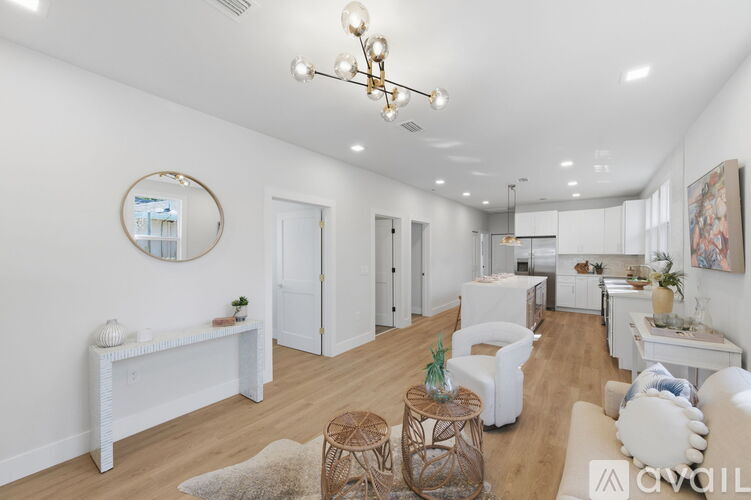 A living room with white furniture and a chandelier.