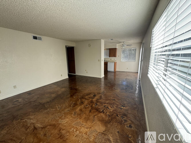 A room with a brown floor and white walls.
