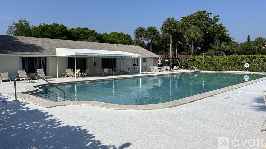 A pool with a house in the background.