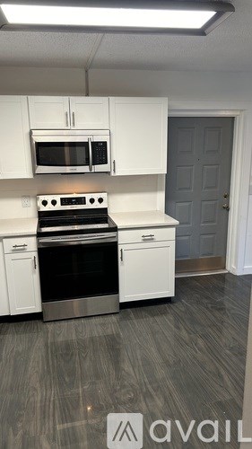 A kitchen with white cabinets and a stainless steel oven.