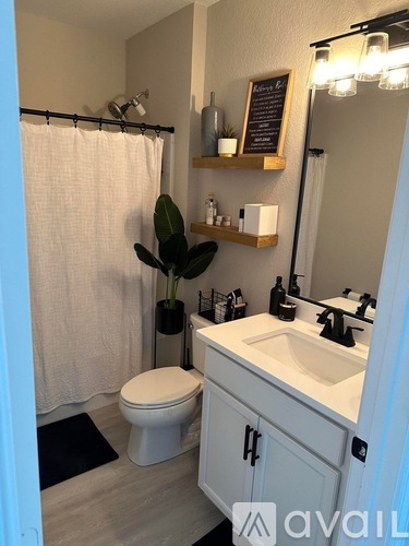A bathroom with a toilet, sink, and mirror.