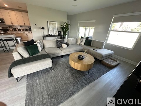 A living room with a grey couch and a wooden coffee table.