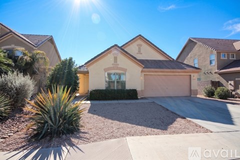 A house with a driveway and a large plant in front.