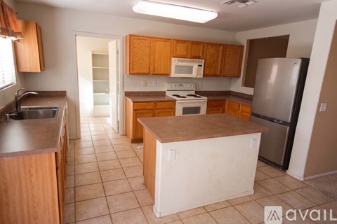 A kitchen with wooden cabinets and a refrigerator.