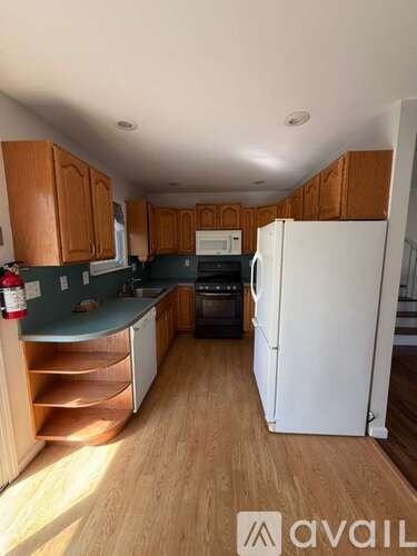 A kitchen with wooden cabinets and a white refrigerator.