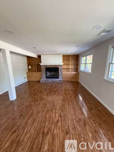 A living room with a fireplace and wood flooring.