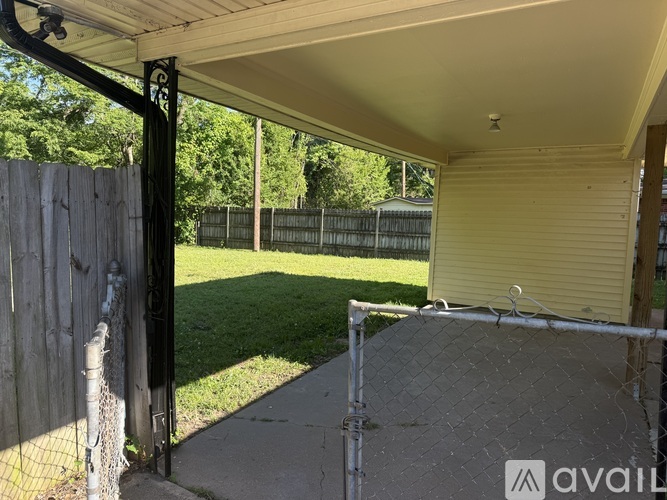 A patio area with a fence and a chain link fence attached to a gate.