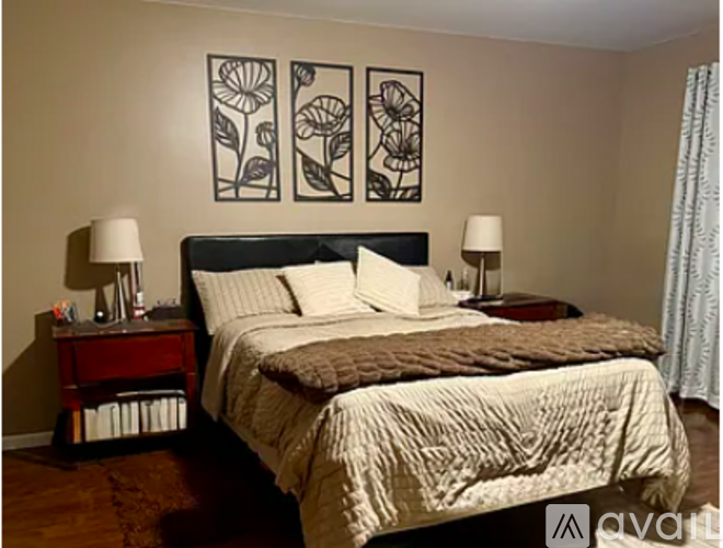 A bedroom with a large bed and two lamps on side tables.