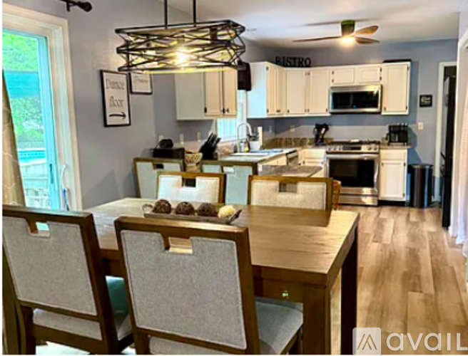 A kitchen with a table and chairs in front of it.