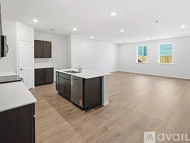 A kitchen with a white countertop and wooden flooring.