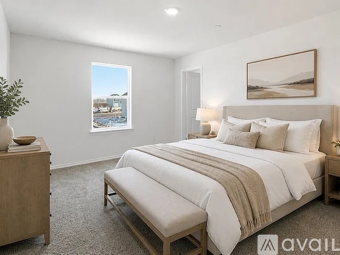 A bedroom with a large bed and a view of a snowy landscape through the window.