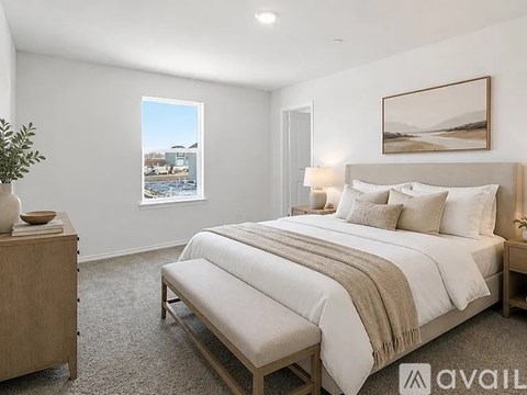A bedroom with a large bed and a view of a snowy landscape through the window.