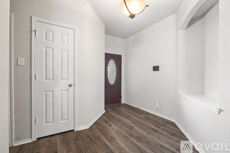 A room with a white door and a wooden floor.