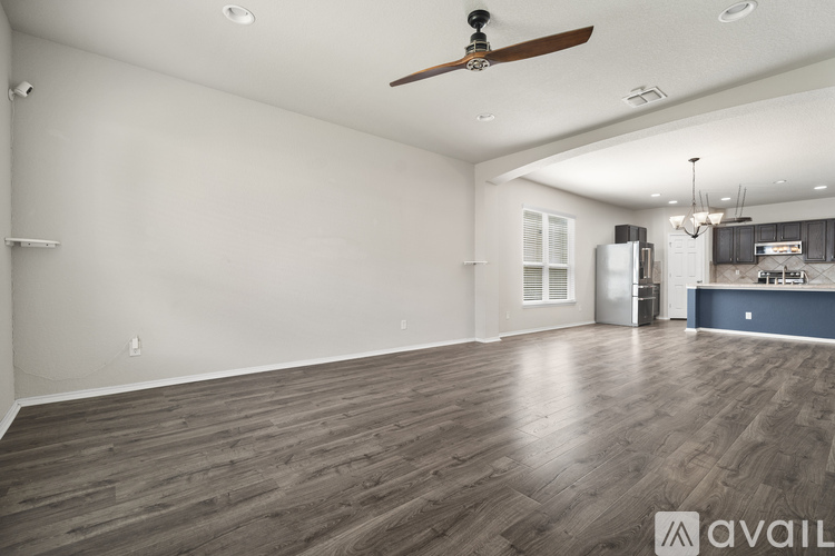 A spacious room with a ceiling fan and wooden flooring.